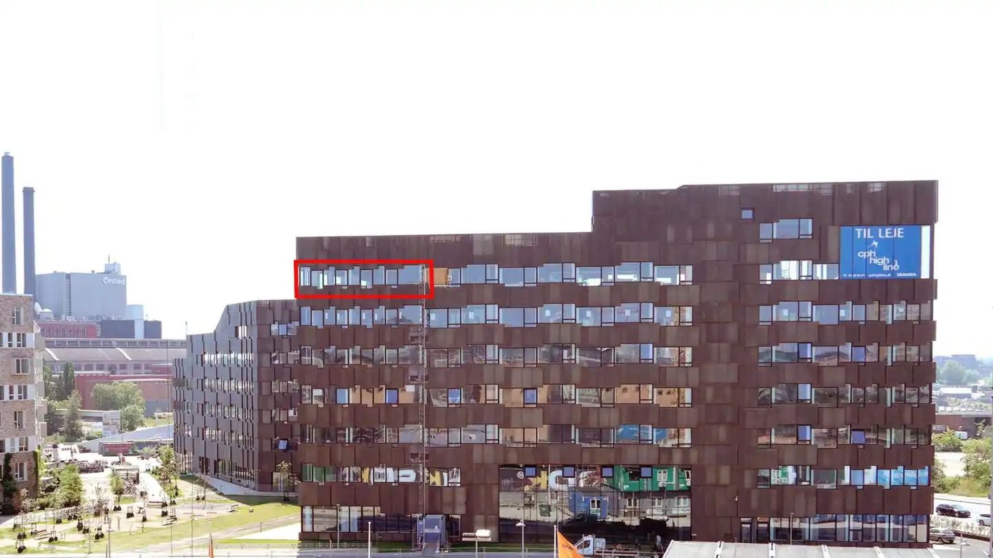 Kontorbyggeri med store vinduer og rustik facade ligger på Havneholmen, tæt på City. Bygningen er i flere etager med mange