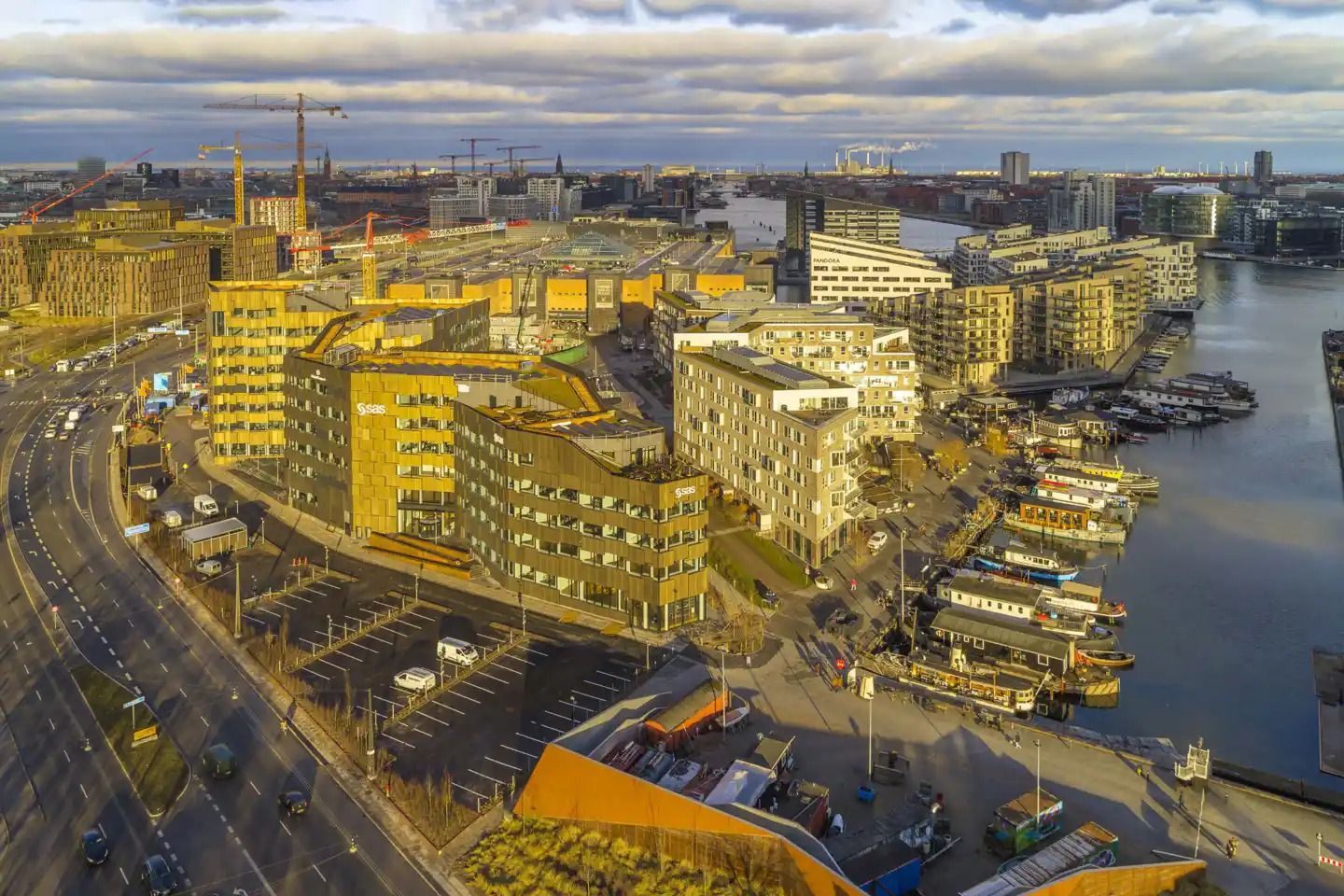 Havneholmen med bygninger, gader, parkeringspladser og skibe, der er forankret ved vandet