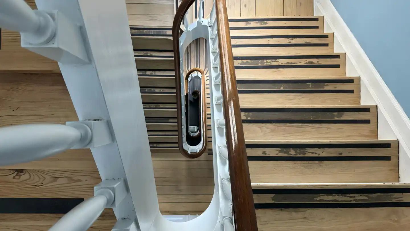 Trætrapper med hvidt og brunt skind og håndtag af hvidt og brunt metal og spejl i håndtaget