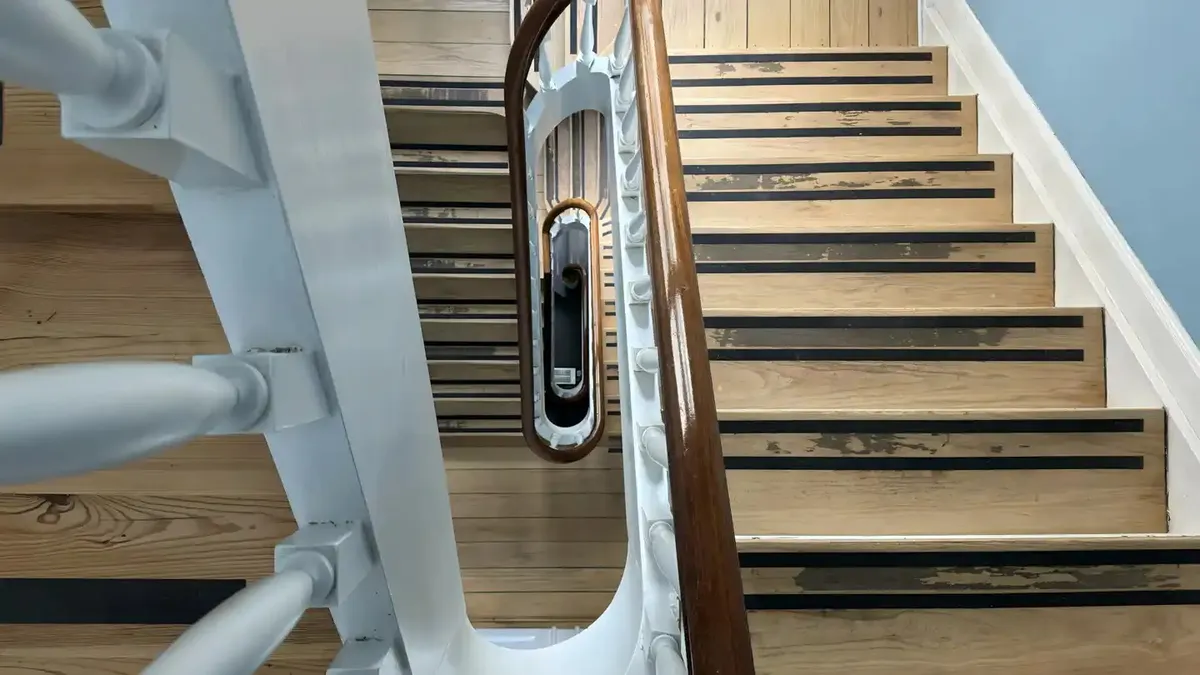 Trætrapper med hvidt og brunt skind og håndtag af hvidt og brunt metal og spejl i håndtaget