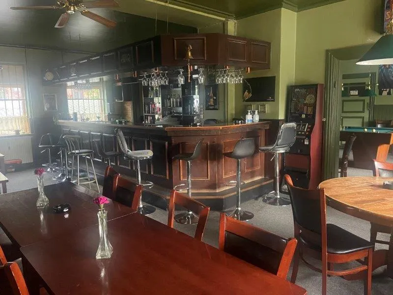 Lejlighed med 111 kvm til leje i Roskilde. Indeholder spisestue med stole og bænke. Bar med flasker og slotsmaskine.