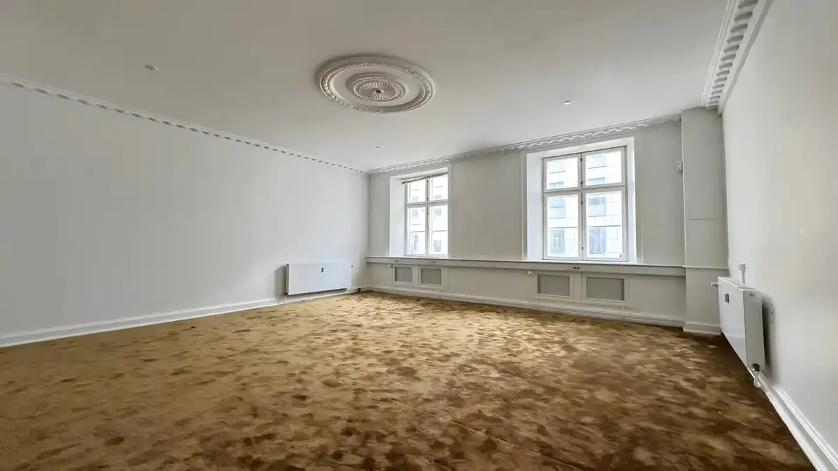 Kontorlokaler med højt til loftet og tavler, hvor der er højt gulv og hvide vægge