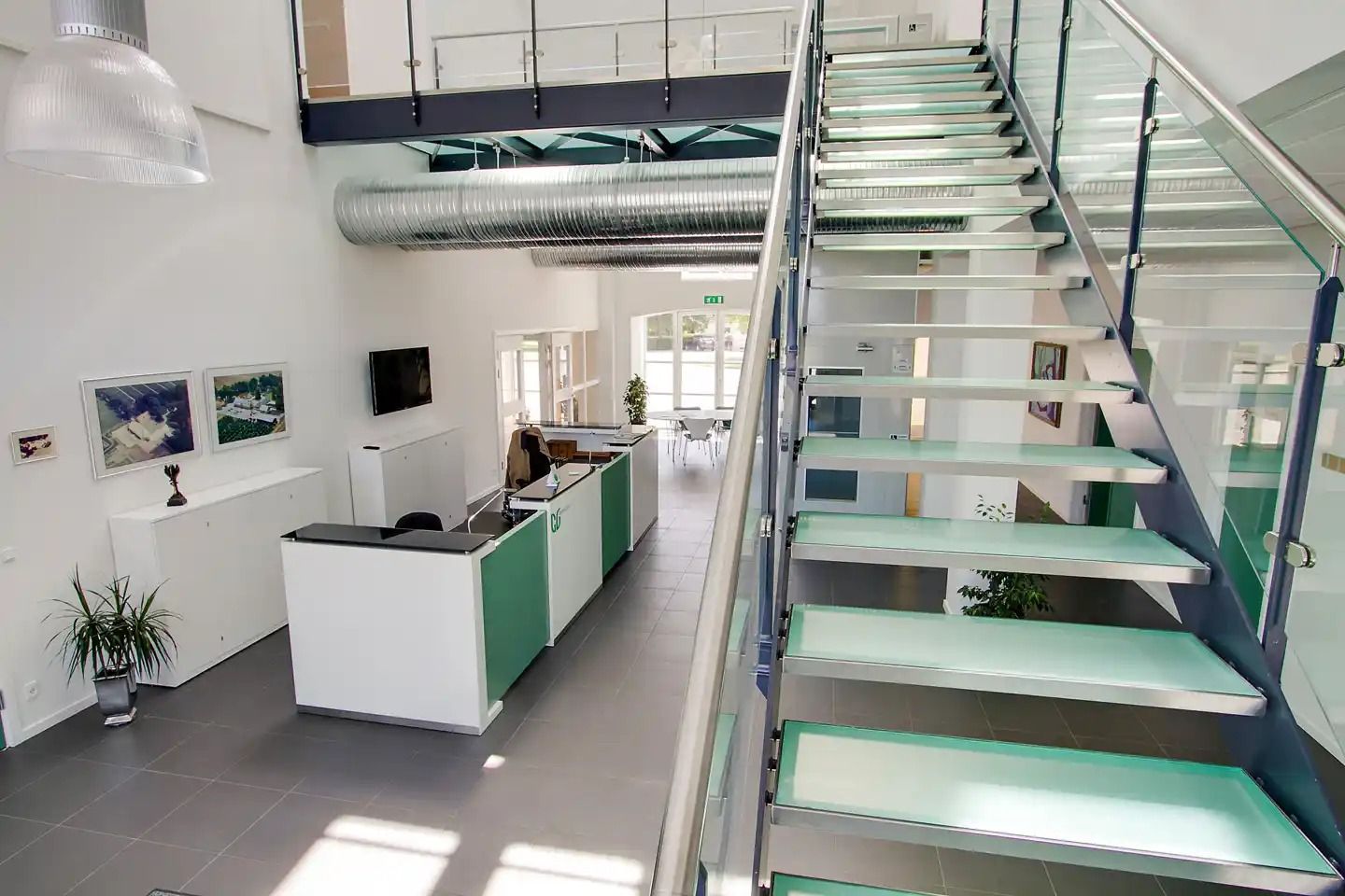 En moderne kontor- og konferencebygning med åbent koncept og grønne glastrapper og gulvbelægning