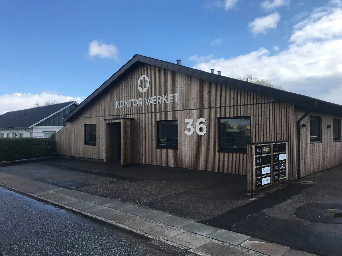 Kontorvirksomhed i Kolding med teksten "KONTOR VÆRKET 36" på facaden og tekster på en infotavle foran bygningen