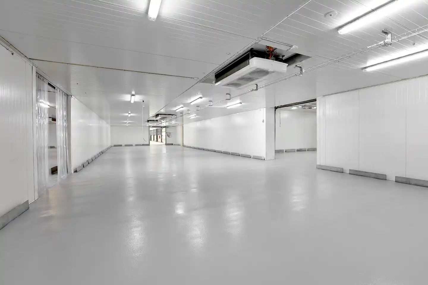 Lagerlejemål med kølefaciliteter Avedøre Holme. Kølerum med hvide vægge og lofter, og en stor automatisk portlukning.