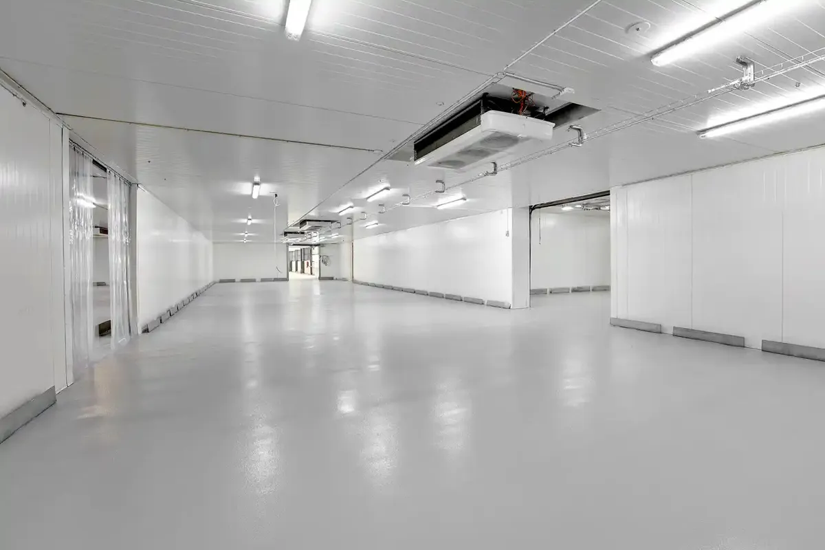 Lagerlejemål med kølefaciliteter Avedøre Holme. Kølerum med hvide vægge og lofter, og en stor automatisk portlukning.