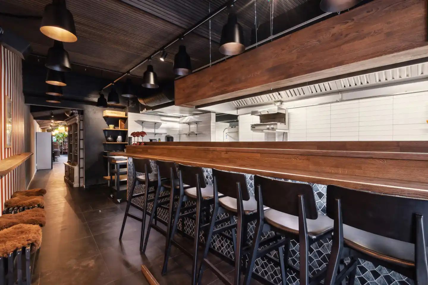 Møbelsmede i København har en moderne interiør med møbler i sort og brun og en længe bar i træ med stolpe og høje stole