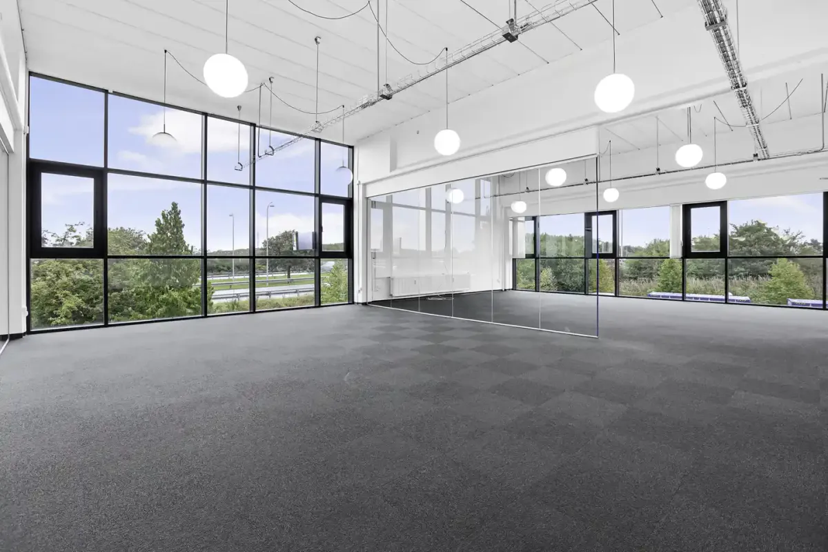 En stor, lys og moderne kontor- eller showroomslokal med store vinduer og spejlvægge