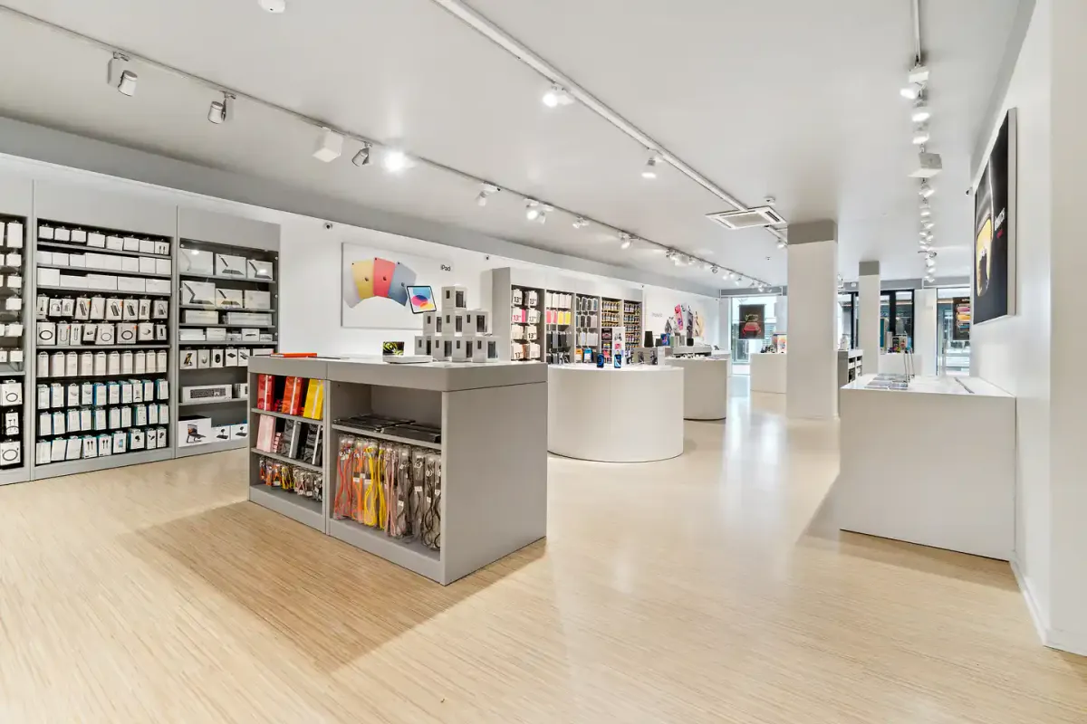 Inde i et højteknologisk butikslokal med møbler og hylder, udstillet produkter og indbygget belysning, og et lyse loft med