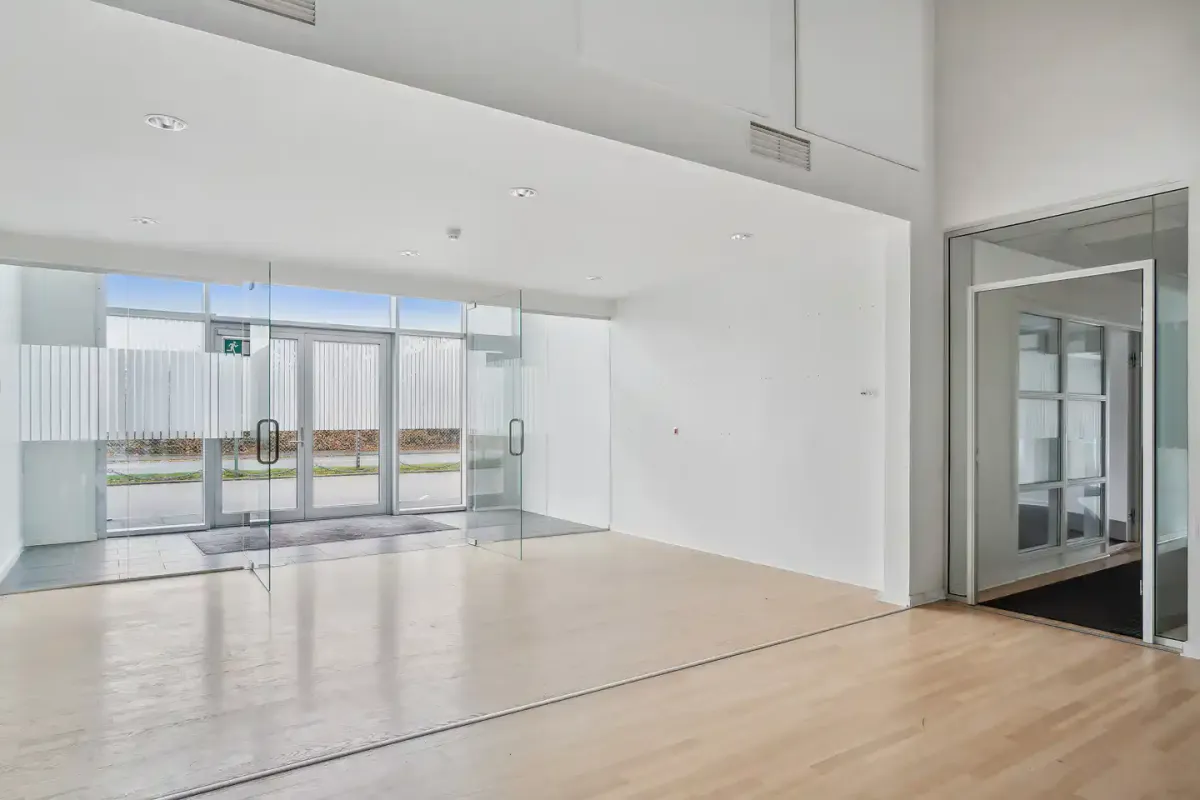 Lukket glasdør med håndtag og tætte gardiner og gulv og vægge af træ og glas