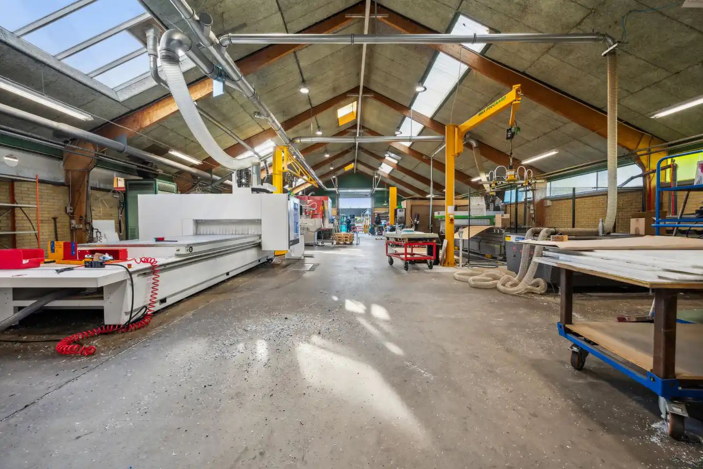 Fabrik indeholder maskineri og værkstedsborde og er belyst af lysekroner og skyggekast fra vinduer