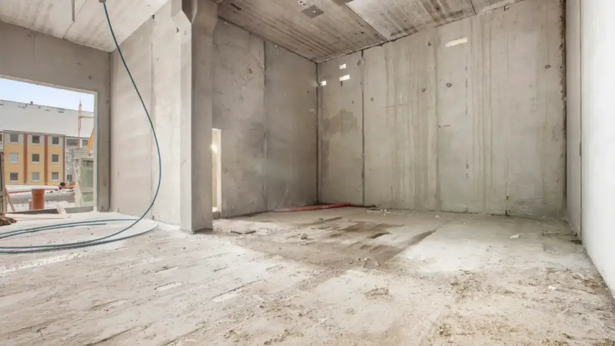 Et byggeprojekt i fuld gang med høje vægge og gulv, tomme rum og støv overalt