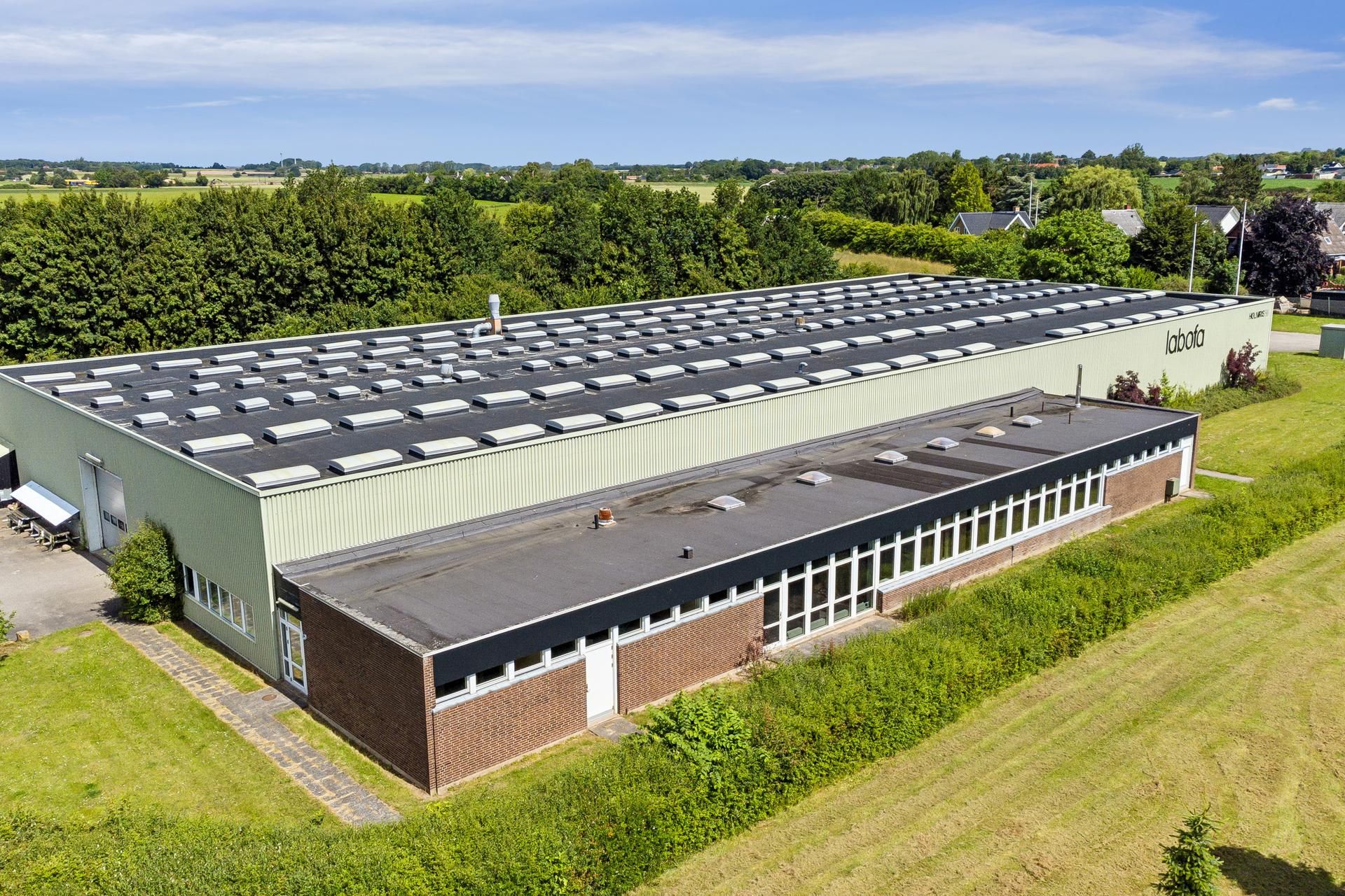 Labofa-bygning med glasruder og solceller på taget og marker i baggrunden