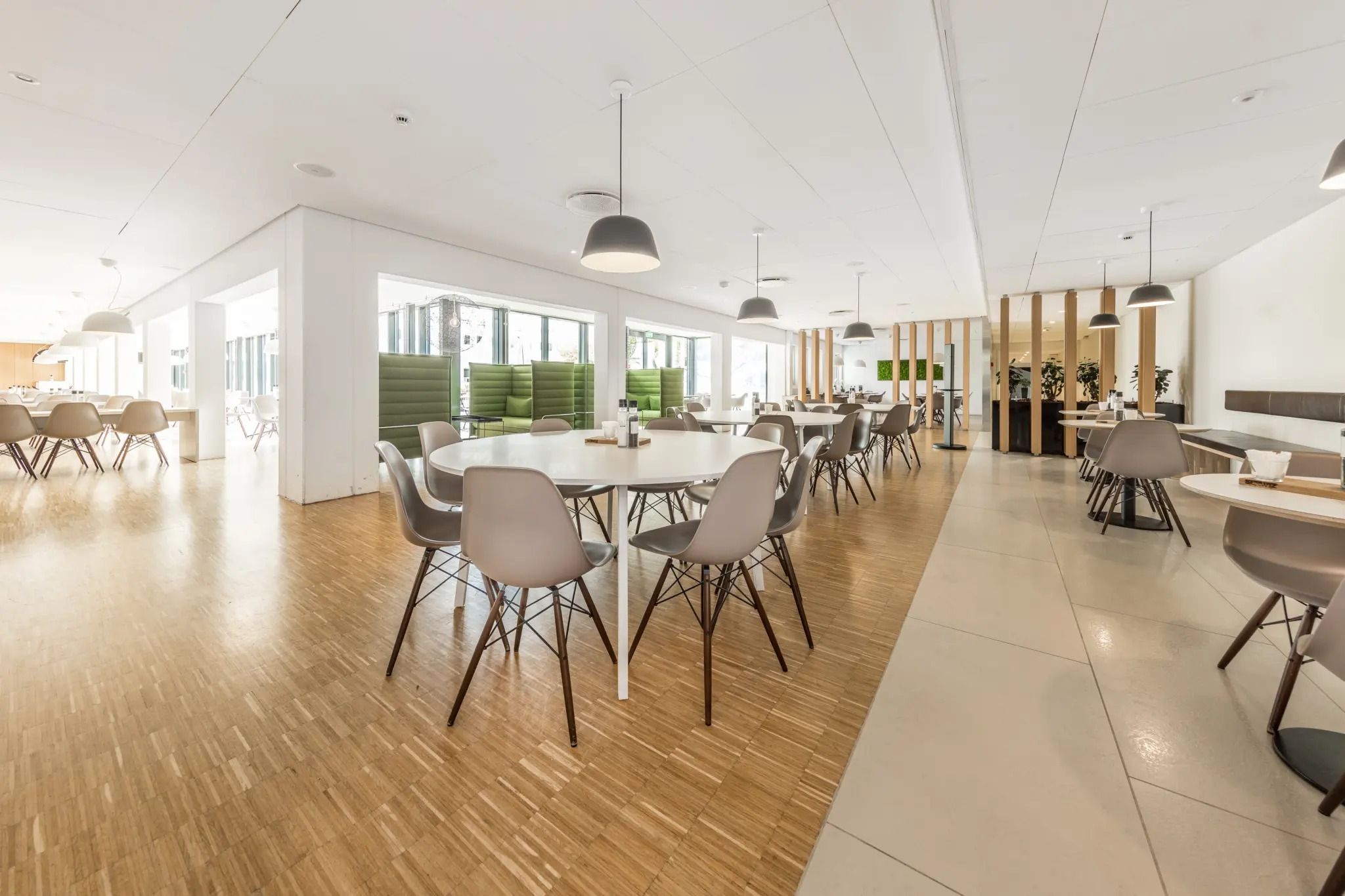 En moderne og ren mødelokale med lyse farver og en stor mængde møbler og vægplanter
