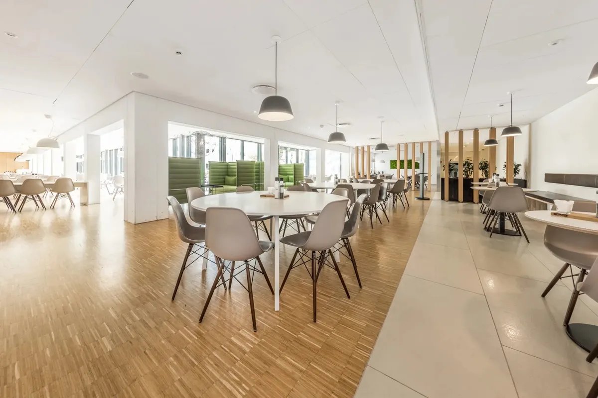 En moderne og ren mødelokale med lyse farver og en stor mængde møbler og vægplanter