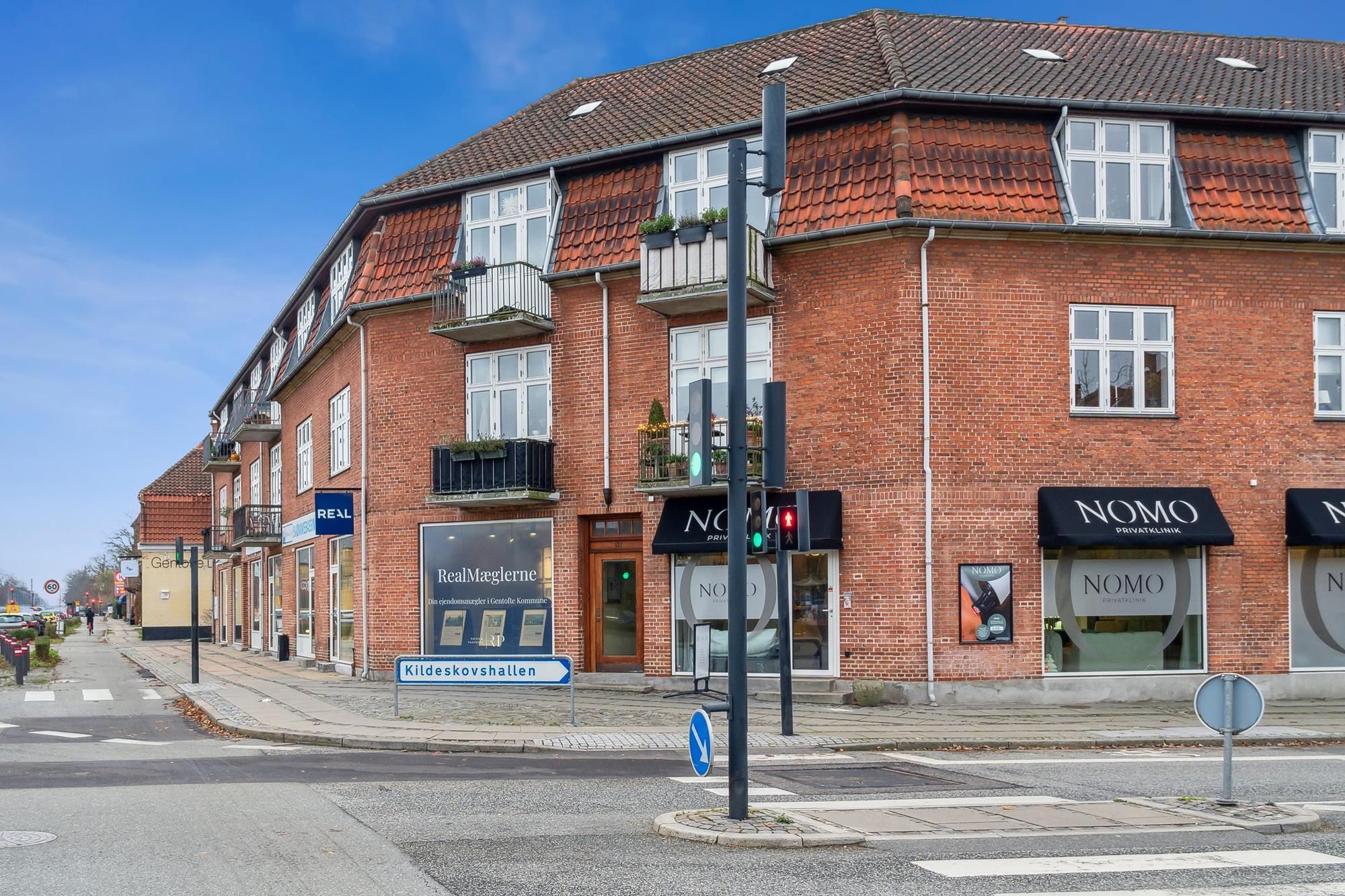 Momsfritaget detaillejemål med store vinduer og udsigt over byen, samt smukke røde mursten og trægavle