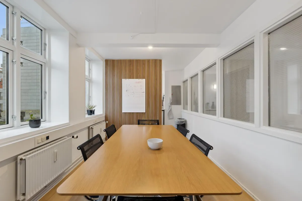 En luksuriøs kontorsal med en stor, træbeklædt væg og lyse vinduer for at give masser af naturligt lys til de moderne