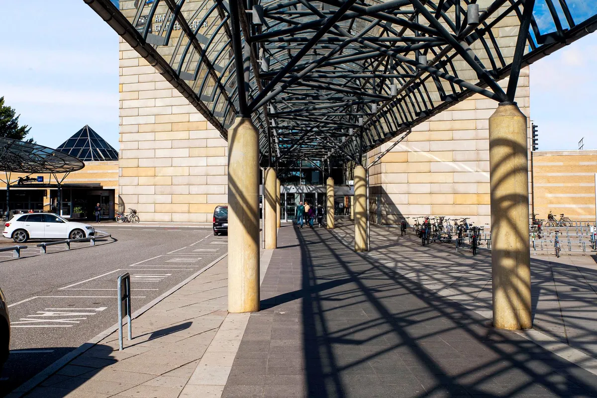 En kontorbygning med moderne design, beskyttet af et metallisk tag og store vinduer