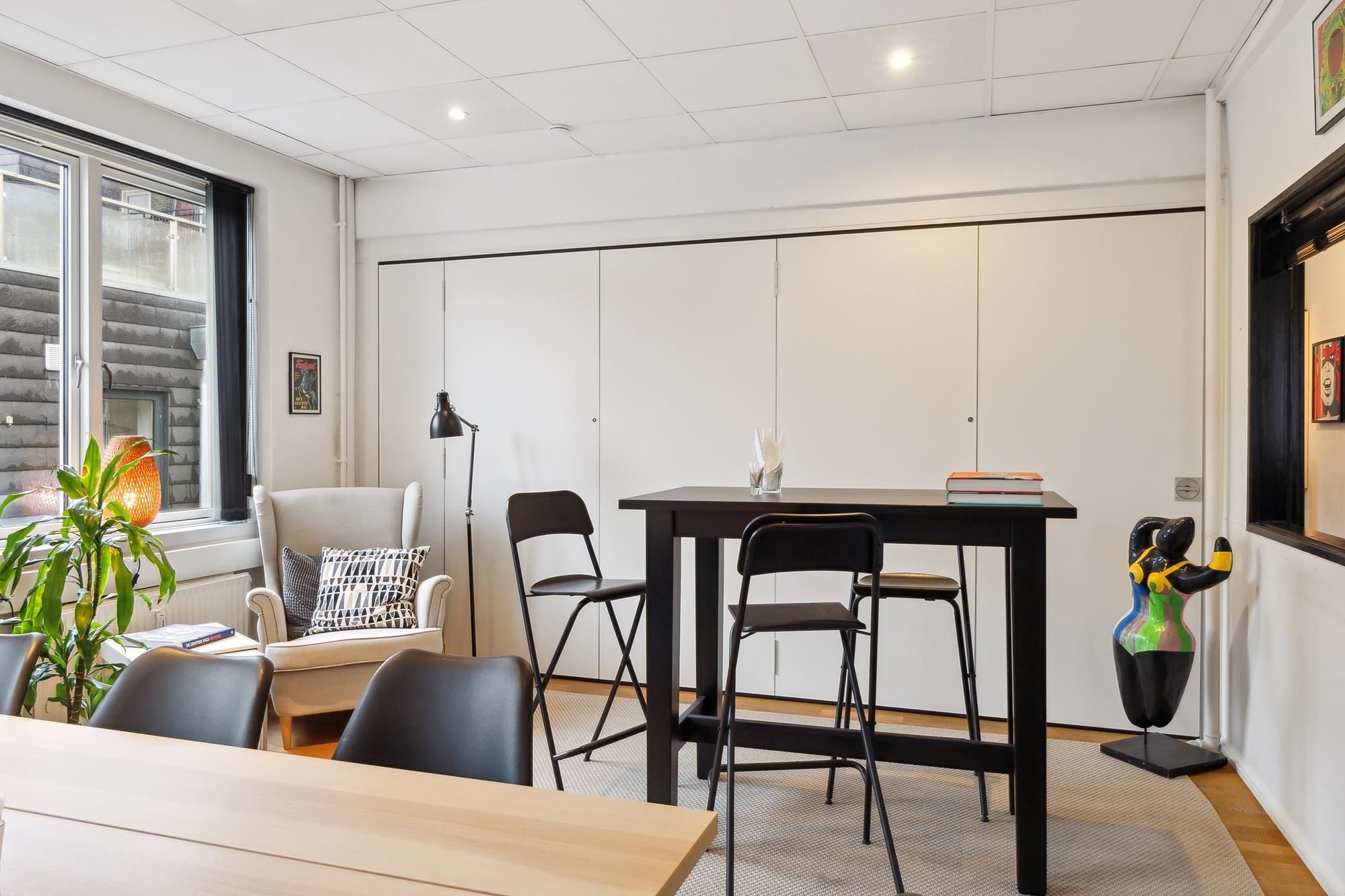 Et moderne og veludstyret værelse med højt til loftet og minimalistisk design