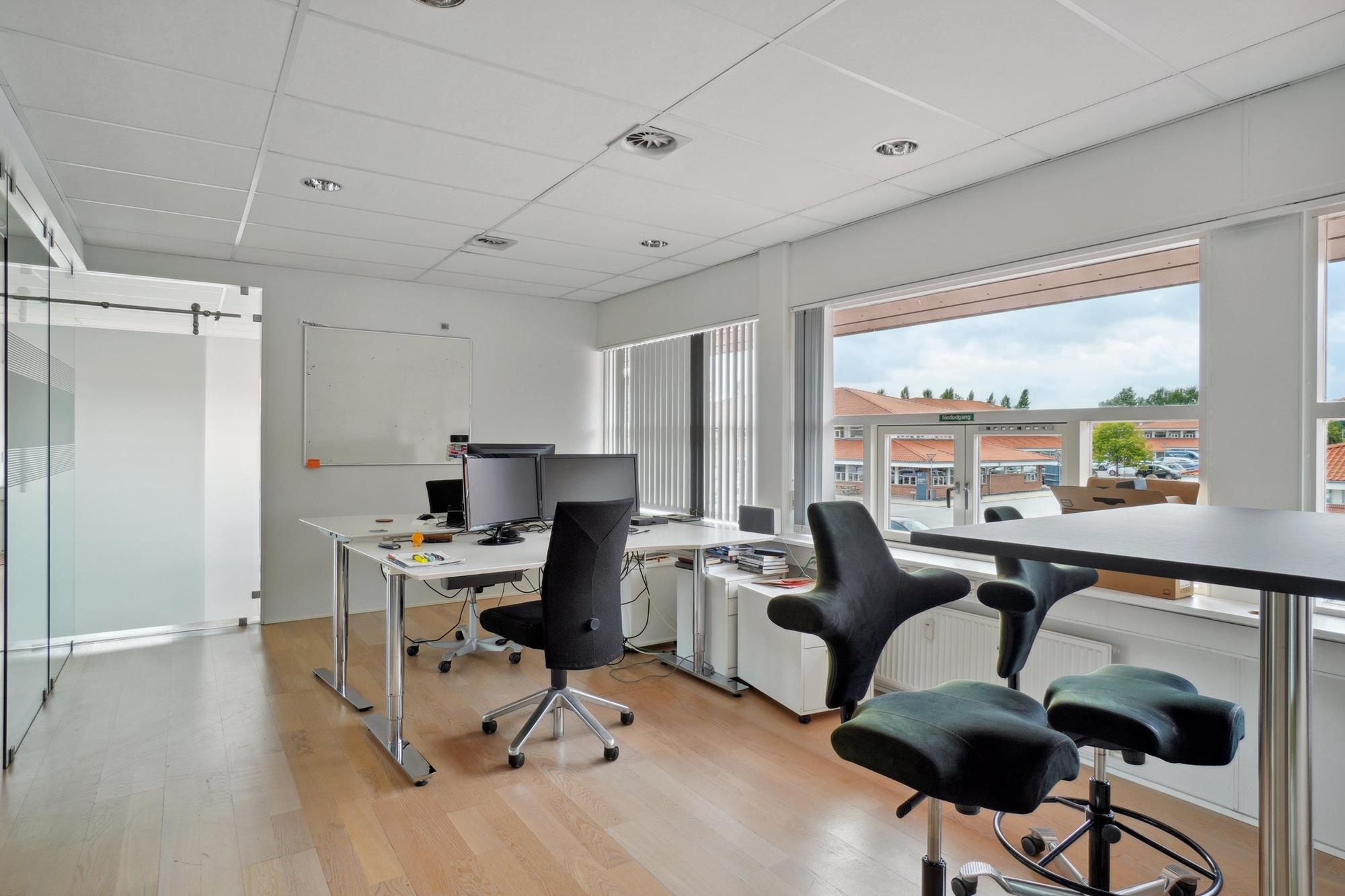 Erhvervspark med lyse og rummelige kontorer og en pæn udsigt til gaden og bygningerne.