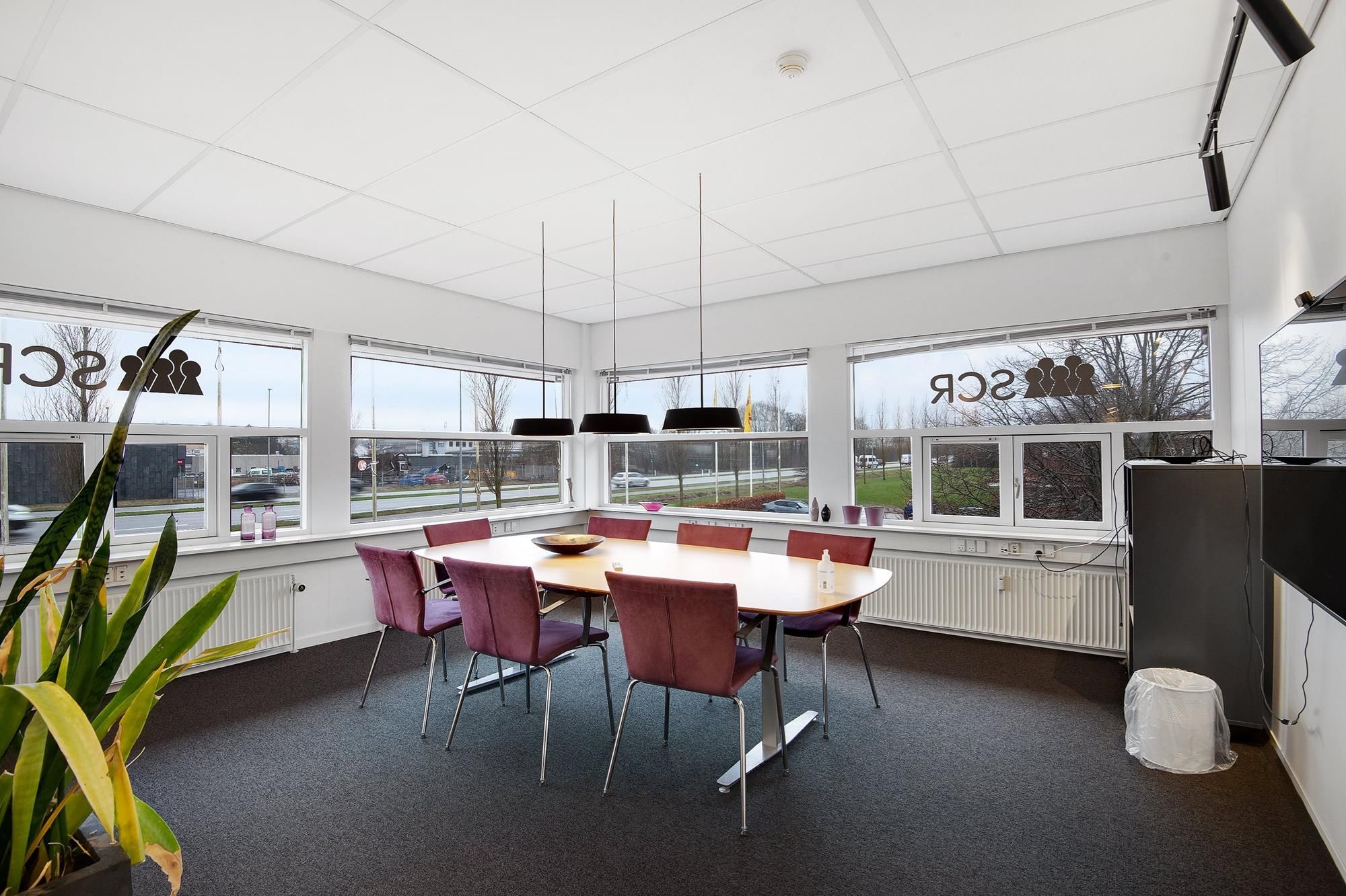 Mødelokale med moderne møbler og lyse vinduer i kontorlokaler med lyse lofter og flotte mødefaciliteter