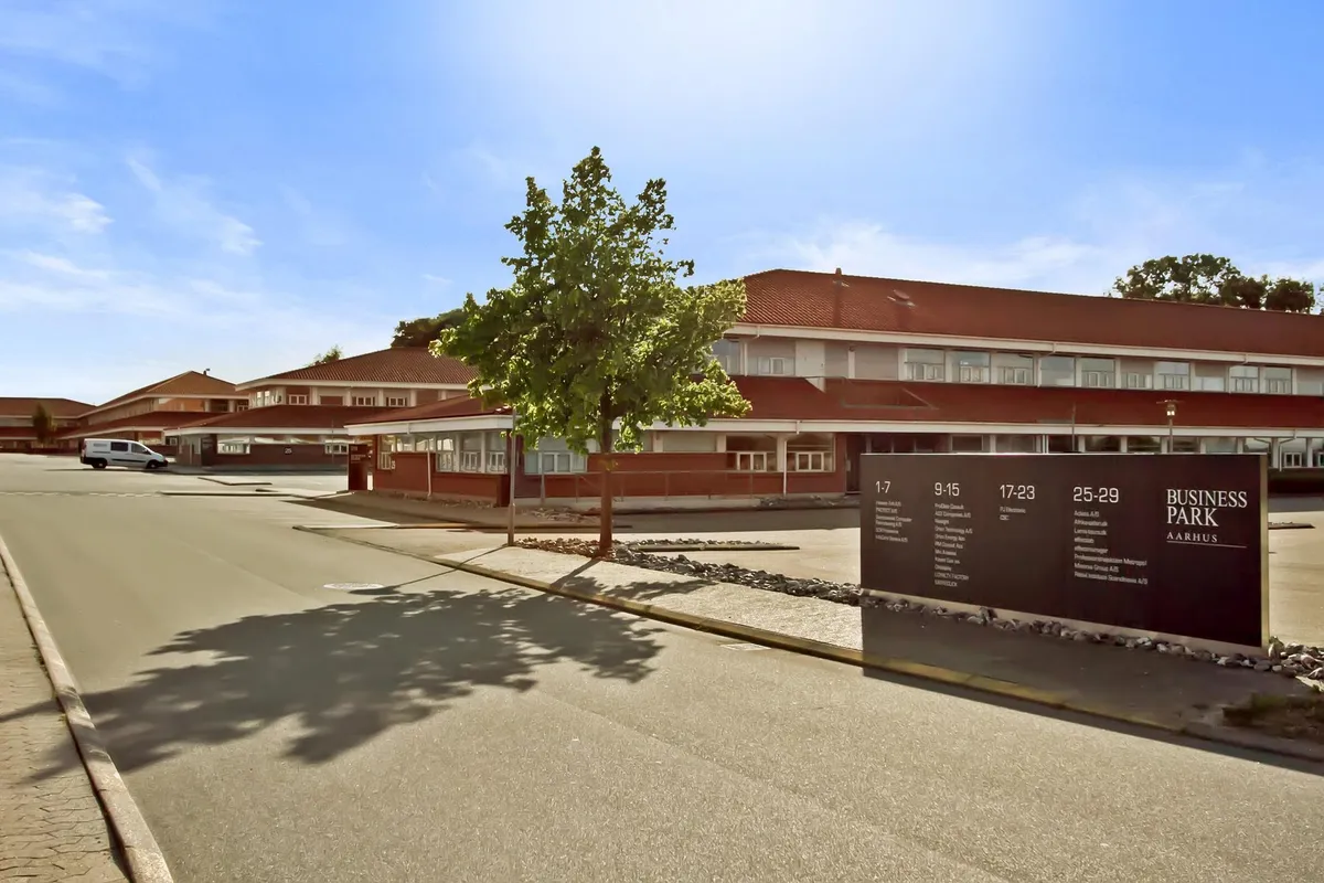 Business Park Aarhus med kontorlokaler og vejvisning, parkeringsplads og grønne områder.