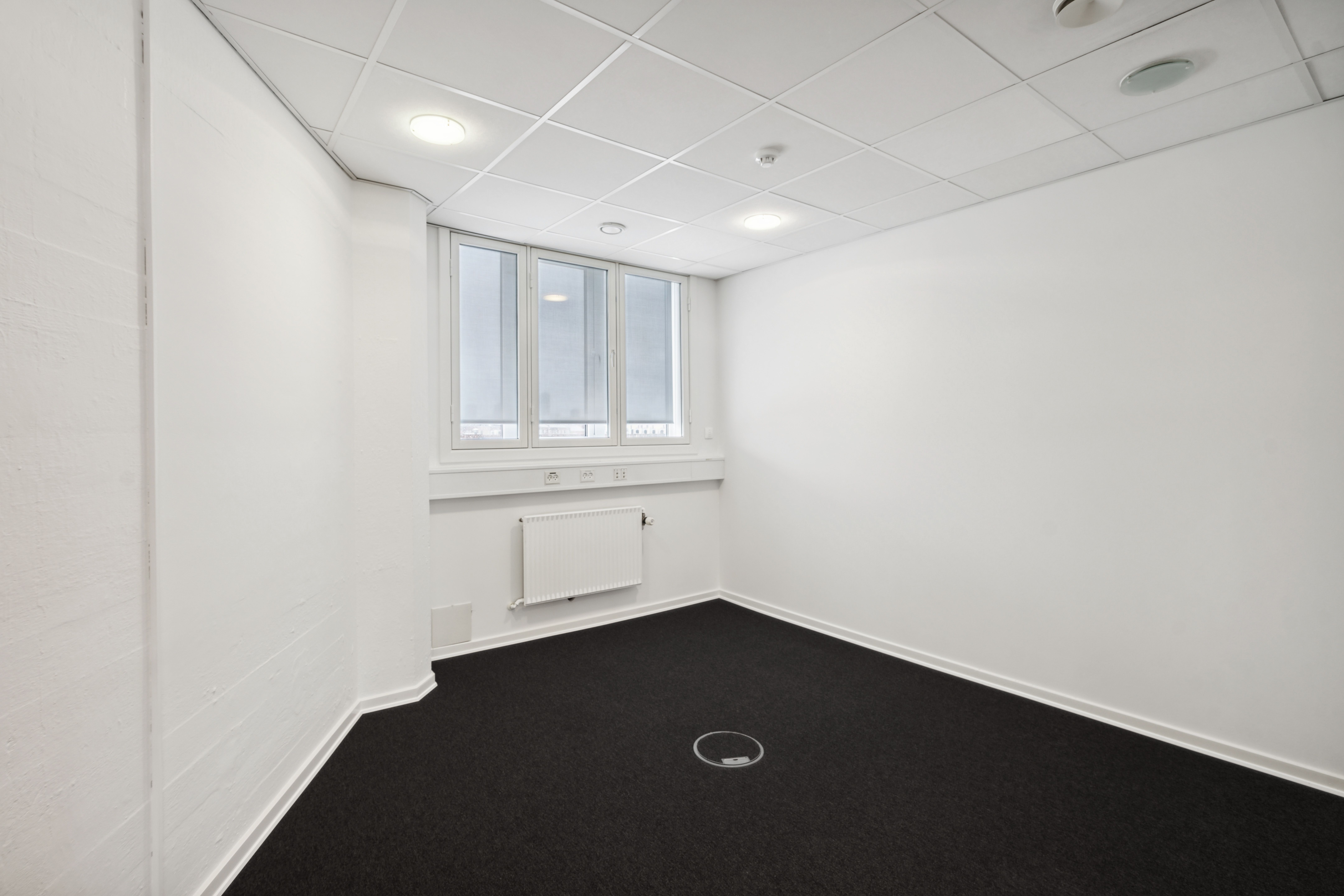 Rummeligt og nyt lejemål med vinduer og radiatorer i Valby. Værelset er fuldstændig hvidmalet og har sort gulv