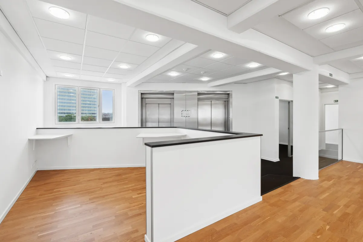 Lejlighed med moderne design og trægulv, hvidt loft og vægge samt to elevatorer for nem adgang til hver etage