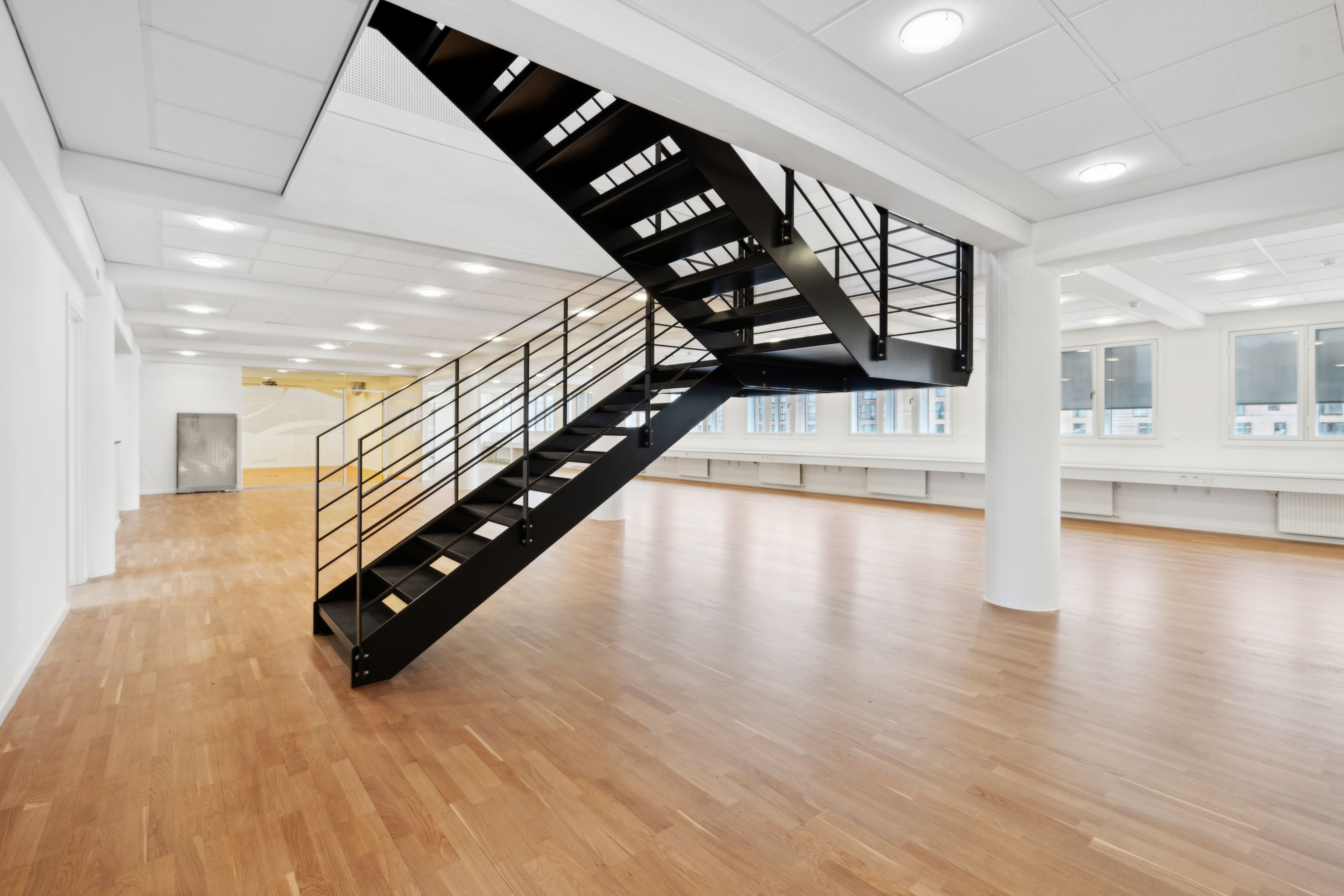 En to-etagers lejlighed med højloft og trægulv er klar til indflytning og har et moderne trappedesign