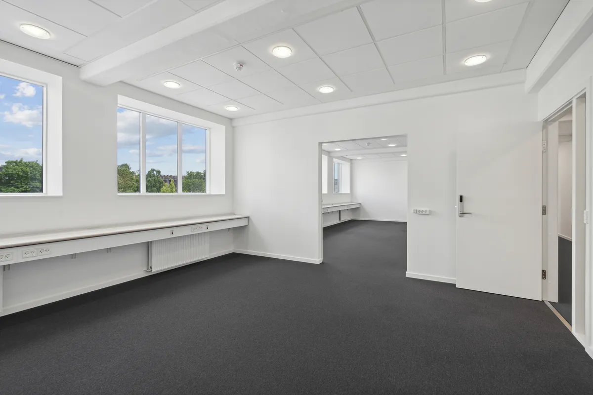 Moderne, lys og ren kontor i Valby med lyse vinduer og hvide vægge, ny gulvbelægning og moderne møbler