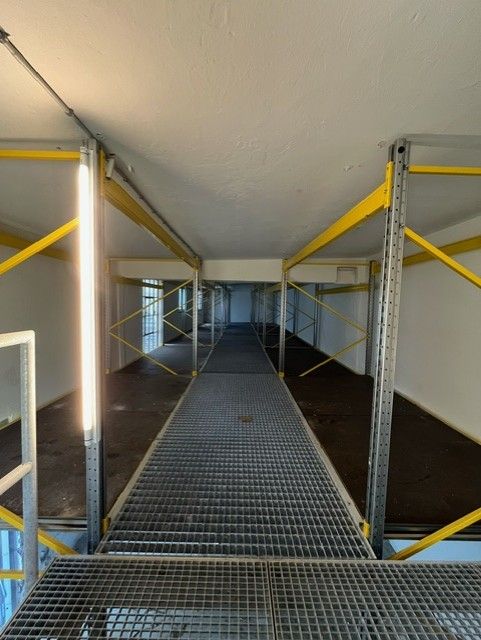 Lager med metalbærere og gulv i københavn. Ingen varer. Det er lyst og luftigt.