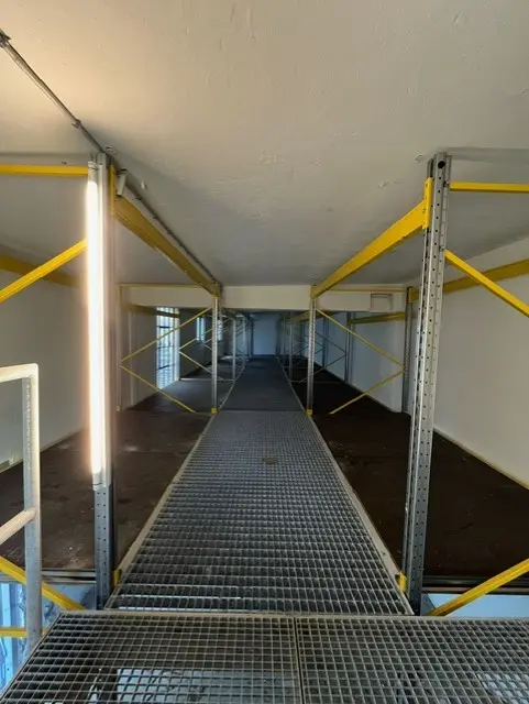 Lager med metalbærere og gulv i københavn. Ingen varer. Det er lyst og luftigt.