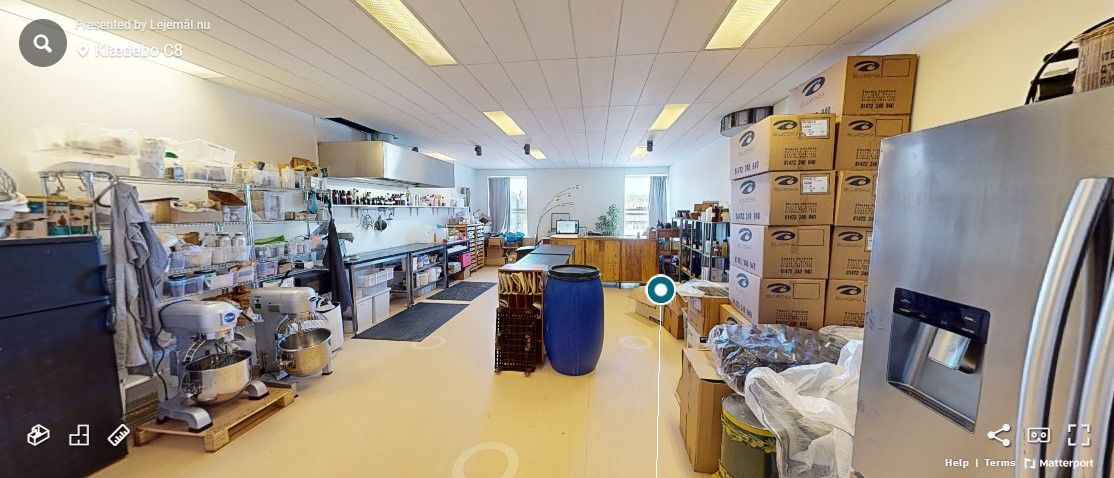 Lager med flere bokse, apparater og beholdere. Styretabel og flere møbler i rummet. Mange apparater og kasser.