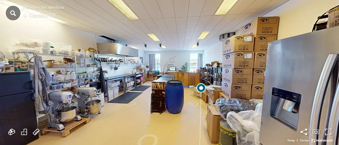 Lager med flere bokse, apparater og beholdere. Styretabel og flere møbler i rummet. Mange apparater og kasser.