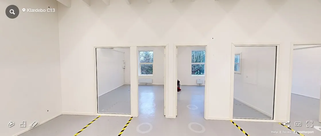 Rummelige værelser med hvide vægge og højloft. Hvert værelse har døre og vinduer. Gulvet er pænt og renset, og der er