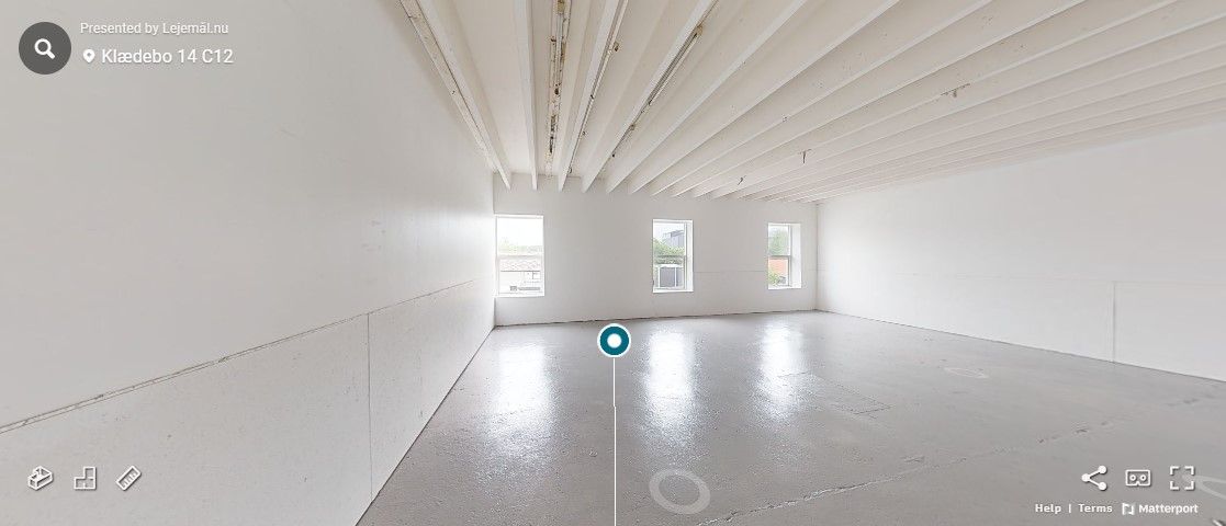 Hørsholms erhvervsområde med rummeligt kontor med hvide vægge, lyse gulvbelægning og vinduer i bagvæggen