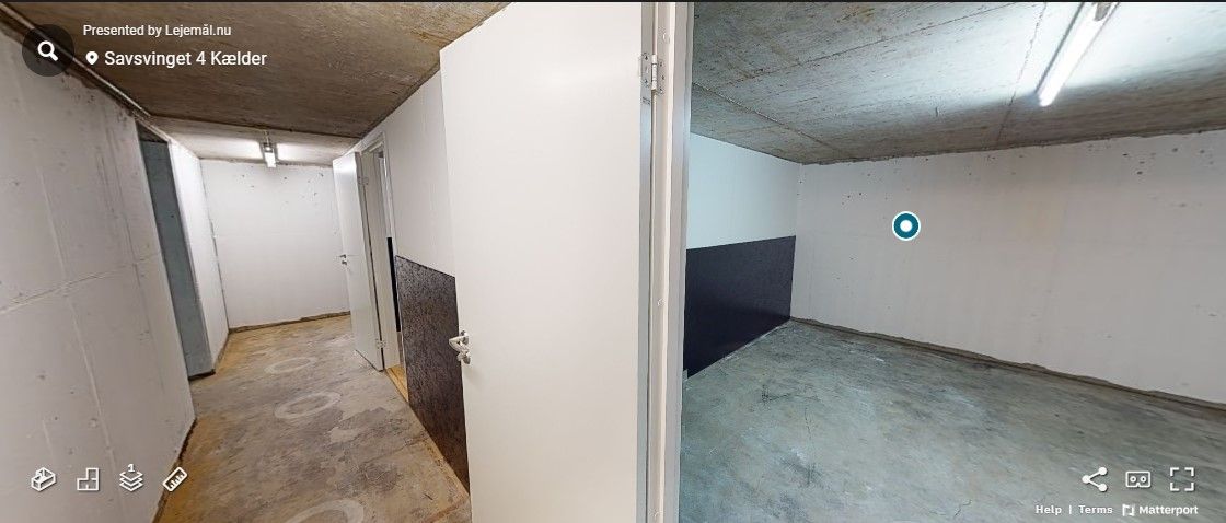 Garagerum med lysegule vægge og mørkegule lofter. Gulvet er ligeledes lysegult. Der er en hvid dør til venstre og en hvid