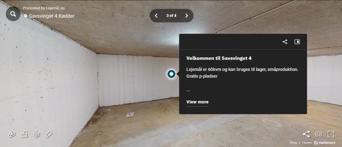 En tom rummelighed med hvide vægge og gulve. En tekstvisning med information om ejendommen, der læser "Velkommen til