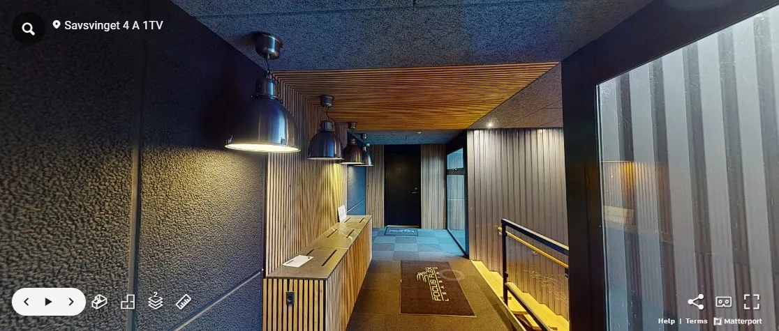 Lyse loftslampe og lysekroner i gangen. Brunt tæppe og lysegule vægge med mønstret loft. Lyserødt gulv og lysegule vægge med