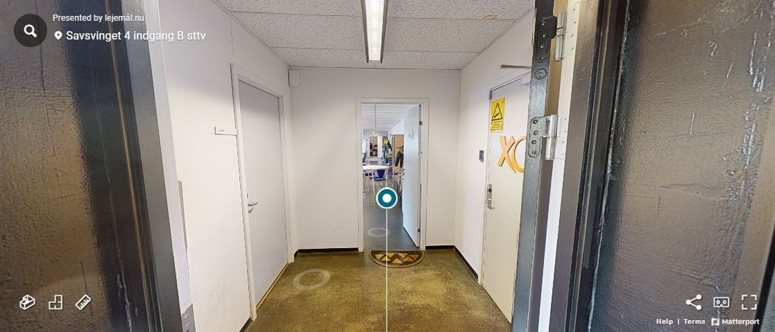 Hallen er mørk og har to døre, der fører ind i rum, og højt til loftet er der en lys. Der er også en gule og sorte skilt og