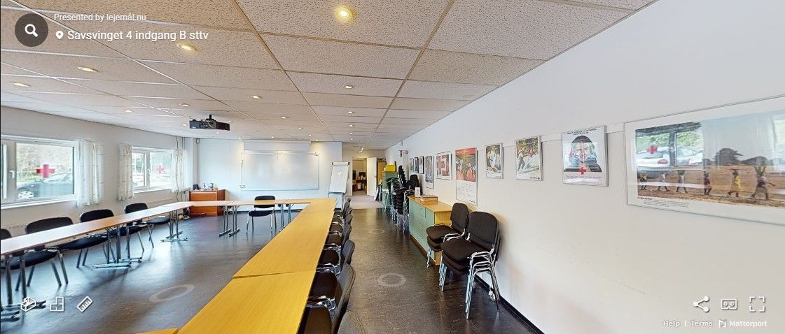 En møde- og konferencelokale med projektionsskærm og lærebord i Savsvinget 4 i Hørsholm.