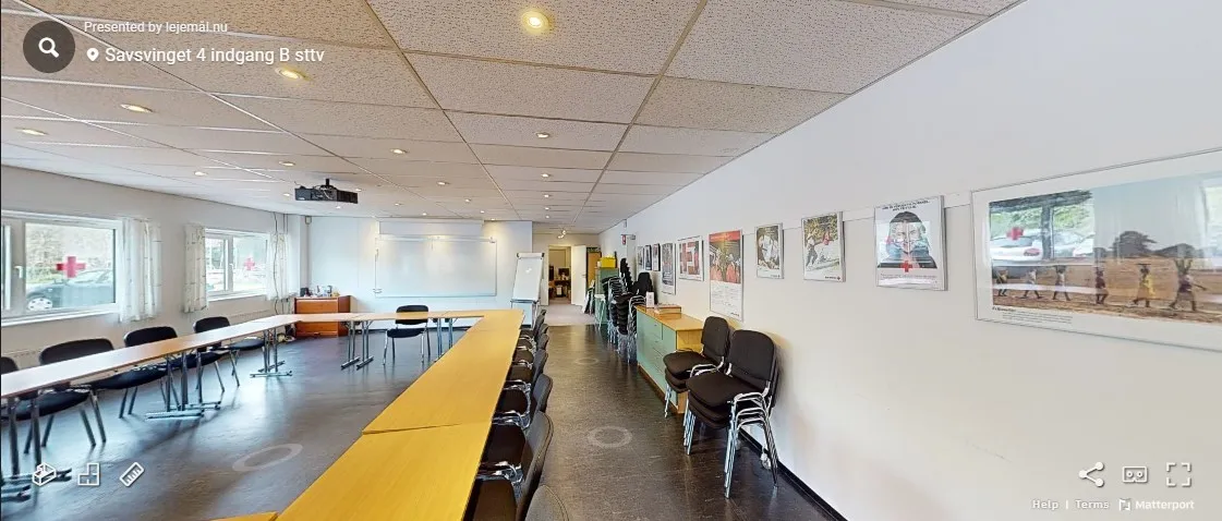 En møde- og konferencelokale med projektionsskærm og lærebord i Savsvinget 4 i Hørsholm.