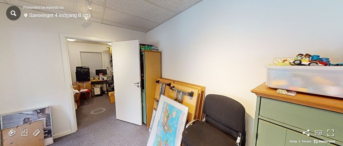 En tom kontorvirksomhed med hvide vægge, gulve og loft, og med en lukket dør og indretning i lyse farver