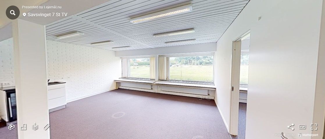 Rum med hvide vægge og lofter, gulvbelægning, vinduer og lysekroner samt en hvid skab med en ovn og en vaskebæk.