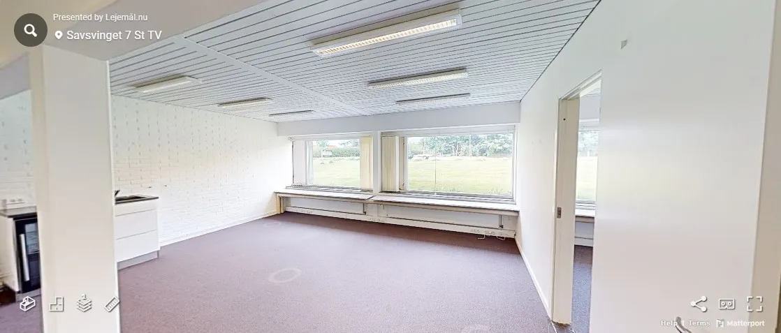 Rum med hvide vægge og lofter, gulvbelægning, vinduer og lysekroner samt en hvid skab med en ovn og en vaskebæk.