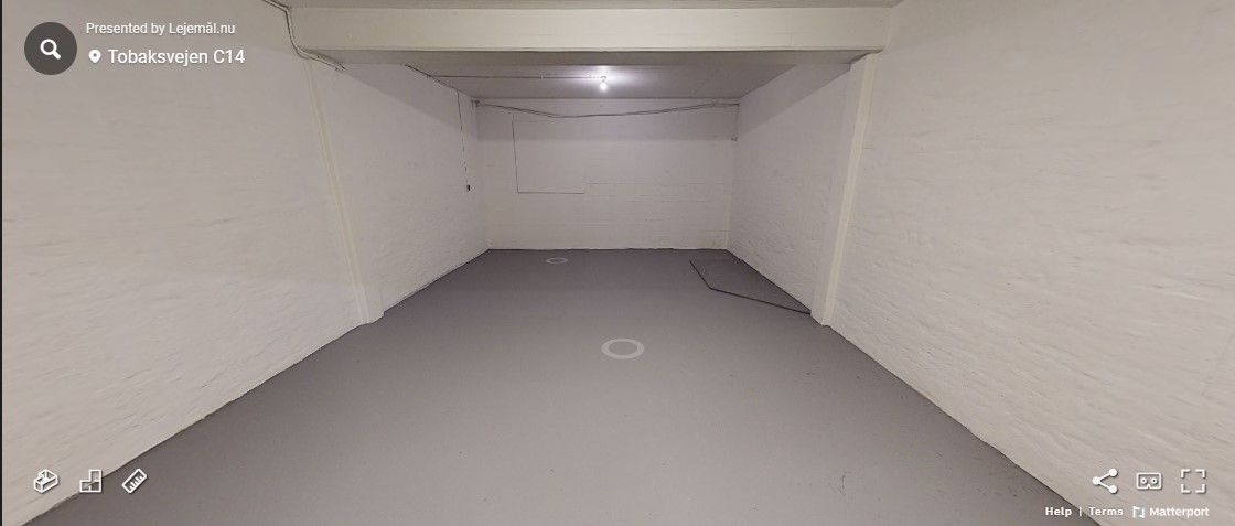 Ledig og rent lagerloft med hvide vægge og gulv og flere lyspunkter i loftet