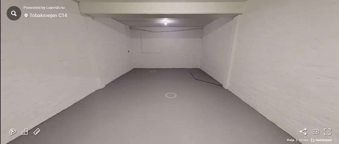 Ledig og rent lagerloft med hvide vægge og gulv og flere lyspunkter i loftet