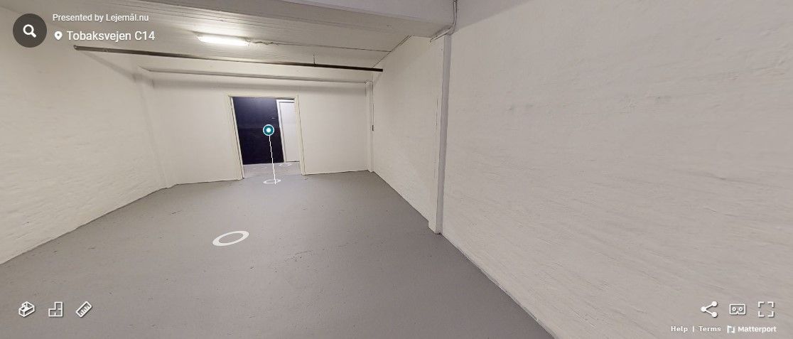 Lejlighed til leje i et lager med hvidvaskede vægge og højt til loftet. Rummet er tomt med en åben dør og en søjle midt på