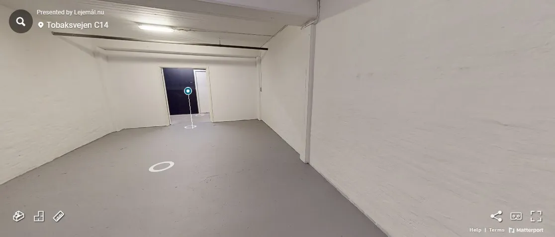 Lejlighed til leje i et lager med hvidvaskede vægge og højt til loftet. Rummet er tomt med en åben dør og en søjle midt på