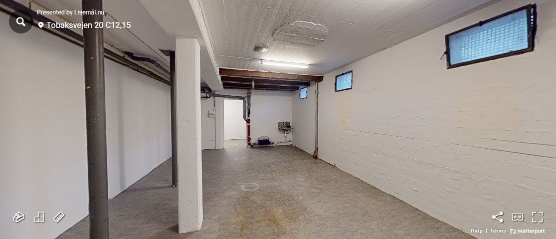 Et stort rum med en hvid væg og en gulv. Der er et lille kammer med et højt vindue. Der er et sving på gulvet. Der er en